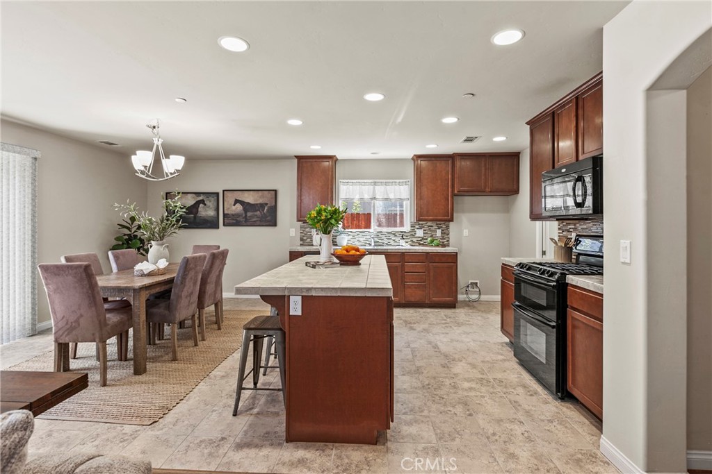 263 Spruce Street, Unit B Arroyo Grande, CA 93420 - Photo 10 of 36 a kitchen with stainless steel appliances kitchen island granite countertop a table chairs sink and cabinets