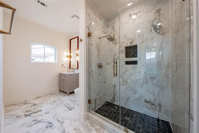 a bathroom with a bathtub shower sink vanity and toilet