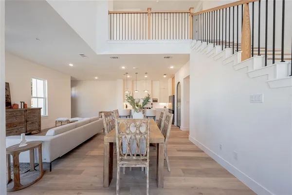 a kitchen with a stove a sink a kitchen island with chairs and wooden floor