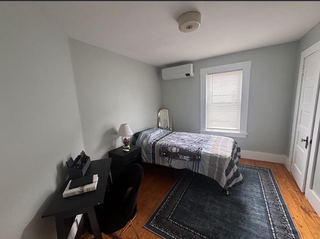 18 Emerald Avenue, Unit 2 Webster, MA 01570 - Photo 20 of 26 a bedroom with a bed and wooden floor