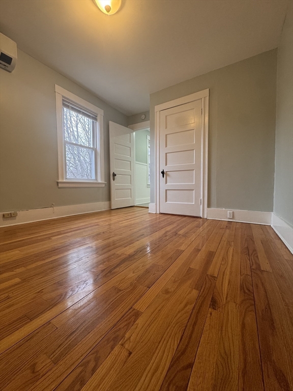 18 Emerald Avenue, Unit 2 Webster, MA 01570 - Photo 21 of 26 a view of an empty room with wooden floor and a window