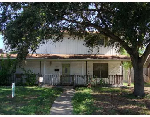 a view of a house with a tree in front of it