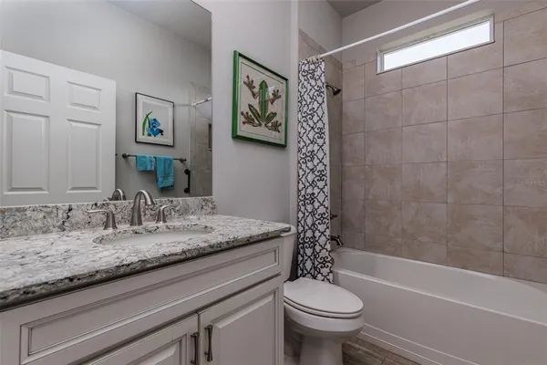 a bathroom with a granite countertop sink a toilet and a bathtub