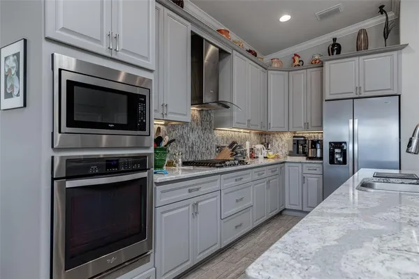 a kitchen with cabinets stainless steel appliances and sink
