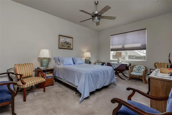 a spacious bedroom with a bed a couch and a window
