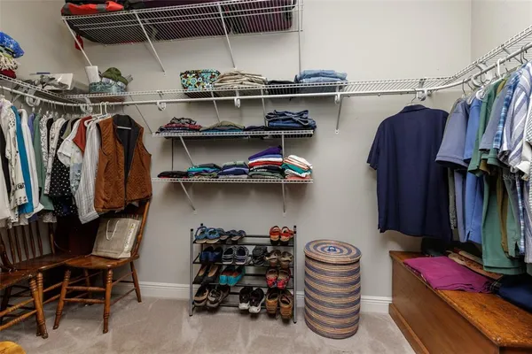 a view of walk in closet with clothes and shoes