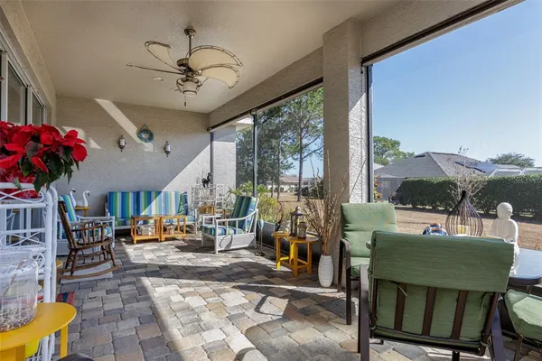 a living room with patio furniture and a chandelier