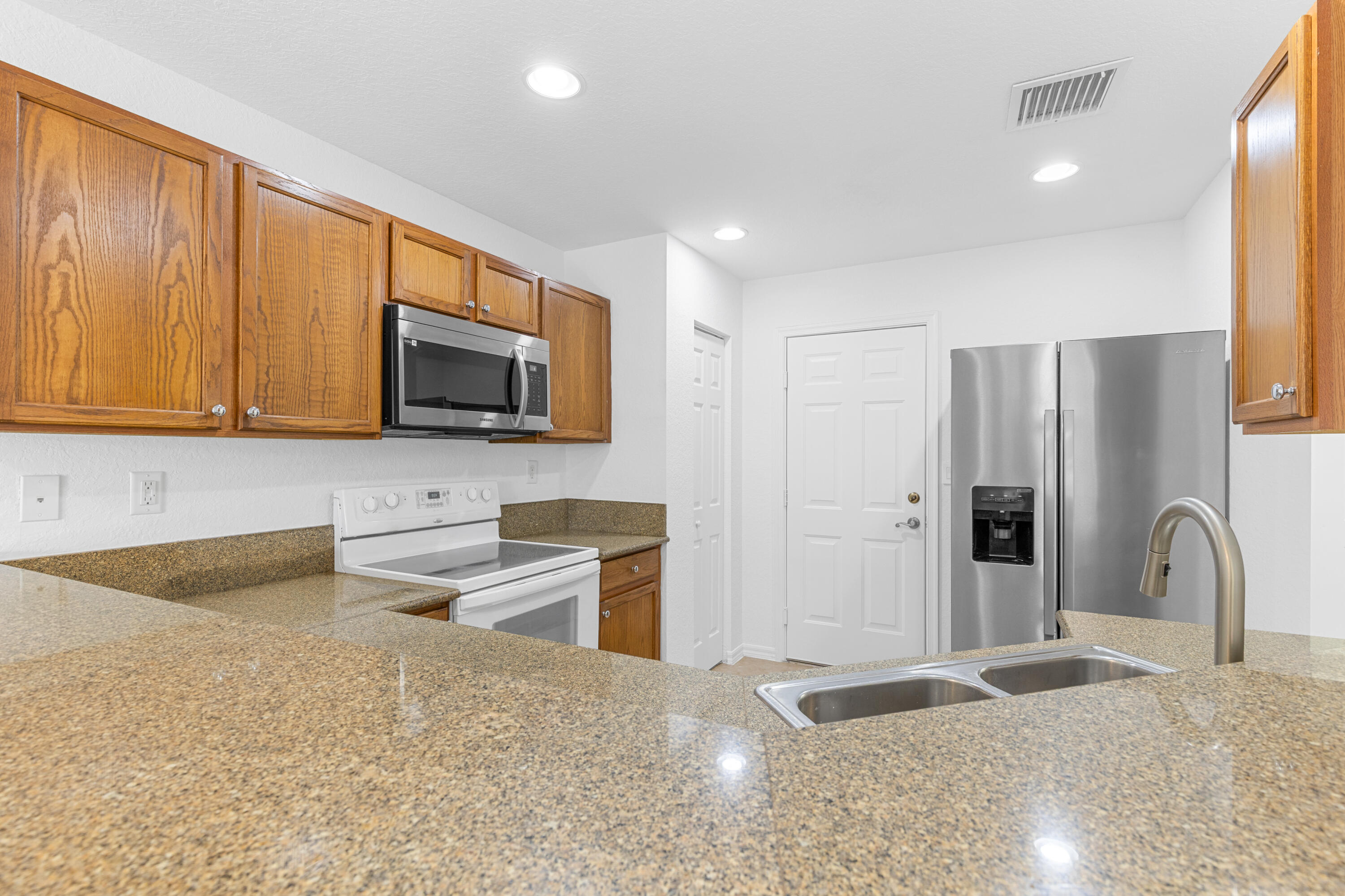 9107 Chambers Street, Unit 9107 Tamarac, FL 33321 - Photo 6 of 30 a kitchen with stainless steel appliances granite countertop a stove a sink and a microwave