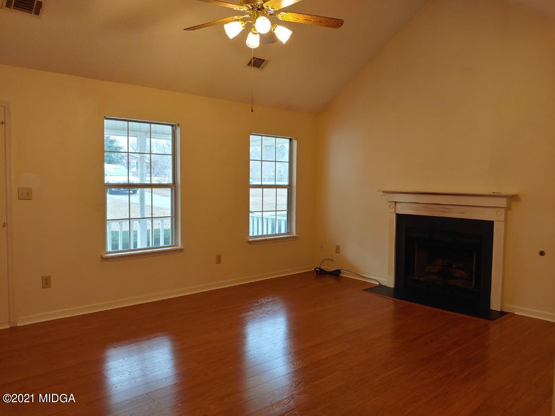 6210 Skipperton Road Macon, GA 31216 - Photo 5 of 15 a view of an empty room with wooden floor fireplace and a window