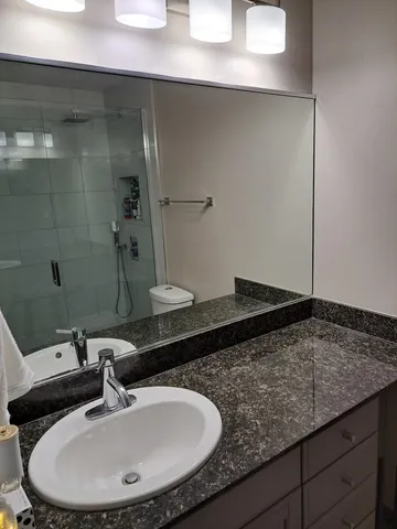 a white toilet sitting next to a shower