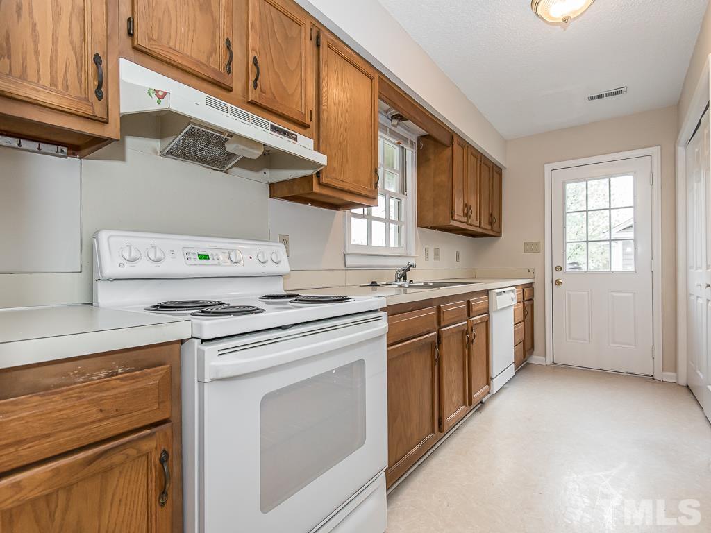 3509 Wickersham Way Raleigh, NC 27604 - Photo 4 of 24 a kitchen with a stove top oven sink and cabinets