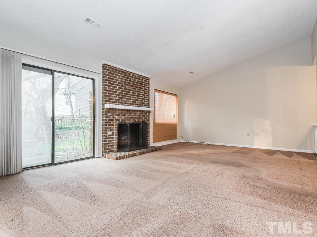 3509 Wickersham Way Raleigh, NC 27604 - Photo 8 of 24 a view of an empty room with a fireplace and a window