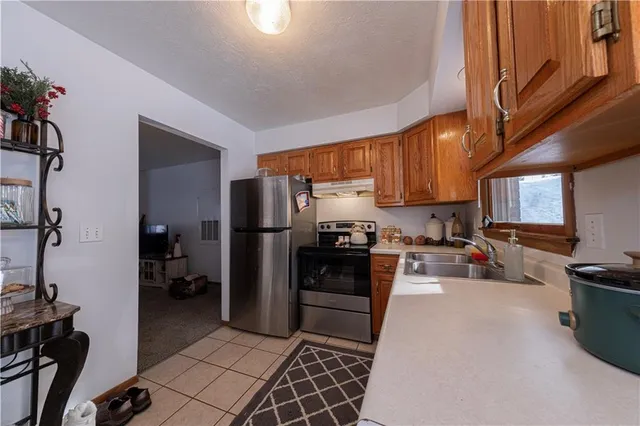 a kitchen with stainless steel appliances granite countertop a refrigerator and a sink
