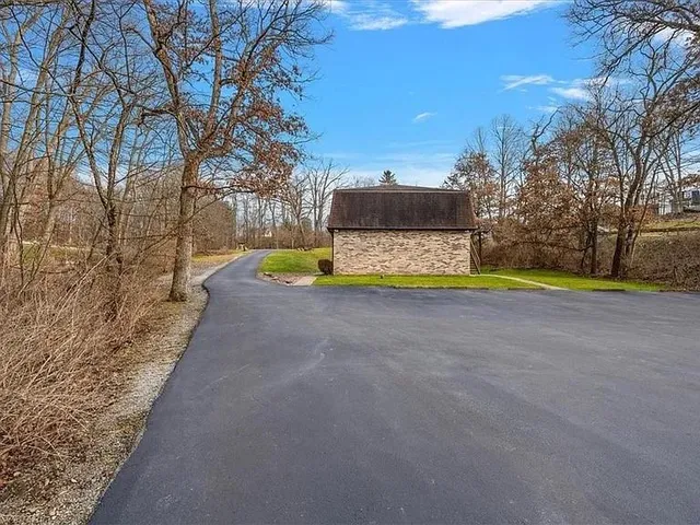 an aerial view of multiple house with large trees