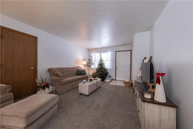 a living room with furniture a chandelier and a flat screen tv