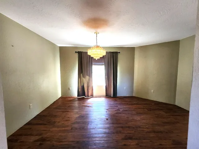 a kitchen with stainless steel appliances granite countertop a refrigerator a stove a sink and a dining table with wooden floor