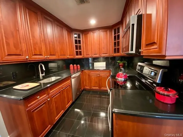 a kitchen with stainless steel appliances granite countertop a sink stove and cabinets