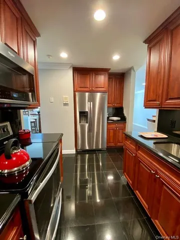 a kitchen with stainless steel appliances granite countertop a refrigerator stove and sink