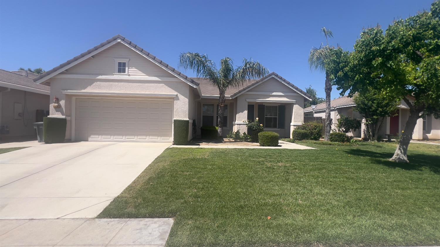 5221 East Byrd Avenue Fresno, CA 93725 - Photo 1 of 15 a front view of a house with a yard and garage