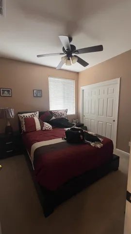a bed room with a bed and a ceiling fan
