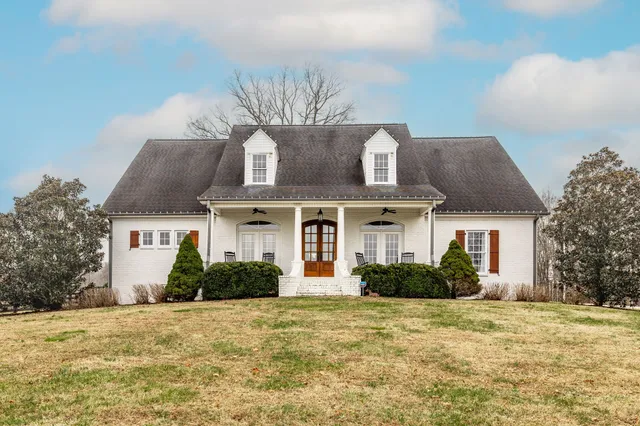 a front view of house with yard and trees around