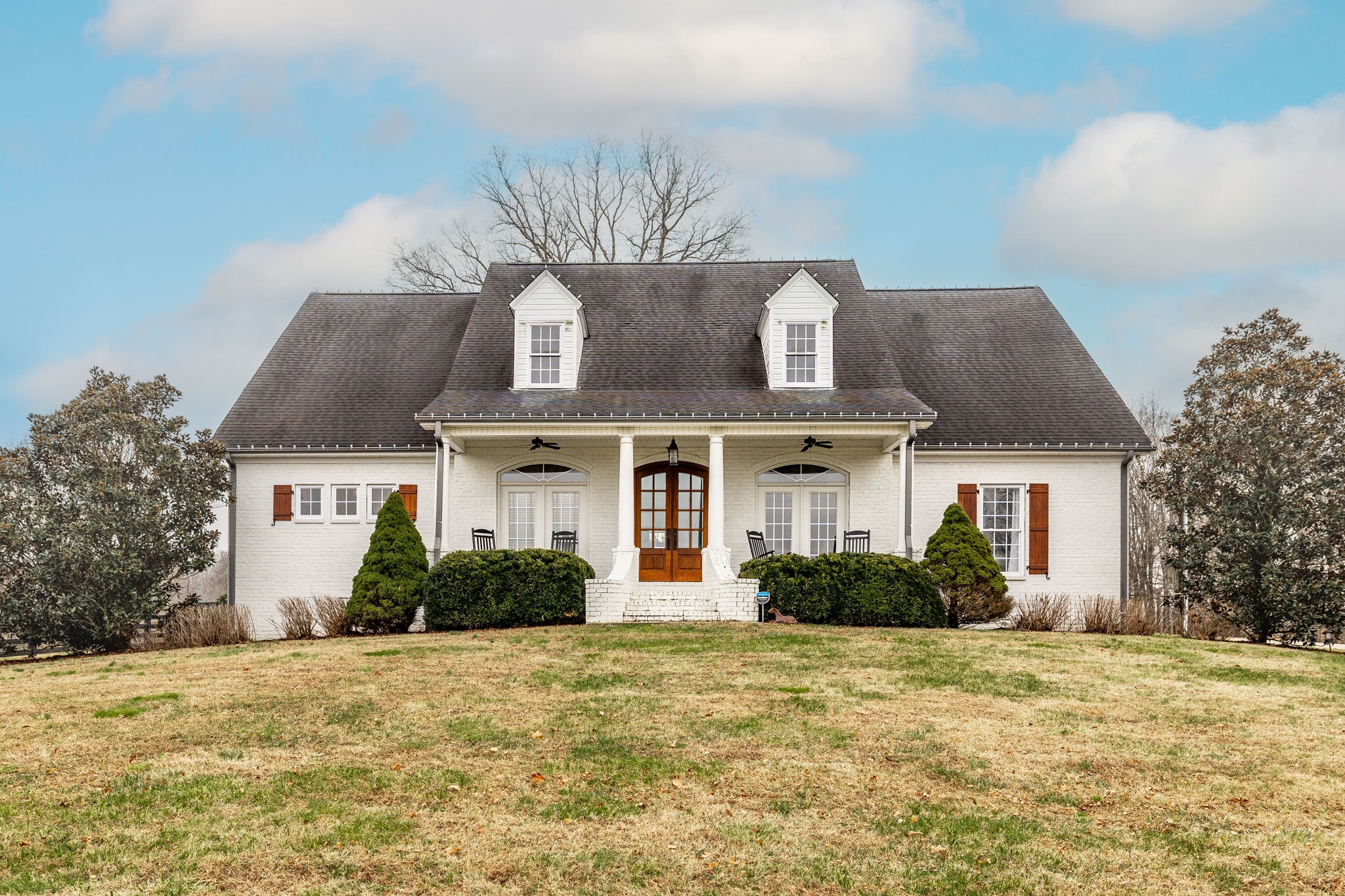 a front view of house with yard and trees around