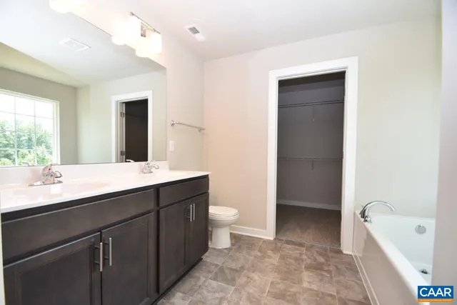 a bathroom with a double vanity sink toilet and shower
