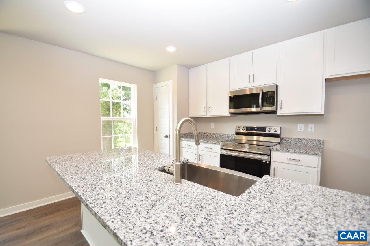 459 Lake Road, Unit HL12B Troy, VA 22974 - Photo 5 of 22 a kitchen with stainless steel appliances kitchen island granite countertop a sink dishwasher a stove top oven a refrigerator with grey cabinets and wooden floor