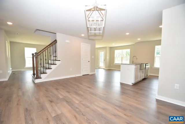 a view of a hallway with wooden floor windows and a kitchen