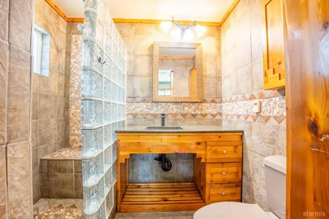 a bathroom with a granite countertop sink and a mirror