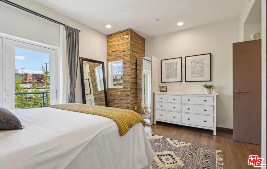 903 South New Hampshire Avenue, Unit 303 Los Angeles, CA 90006 - Photo 13 of 33 a bedroom with a bed closet and mirror