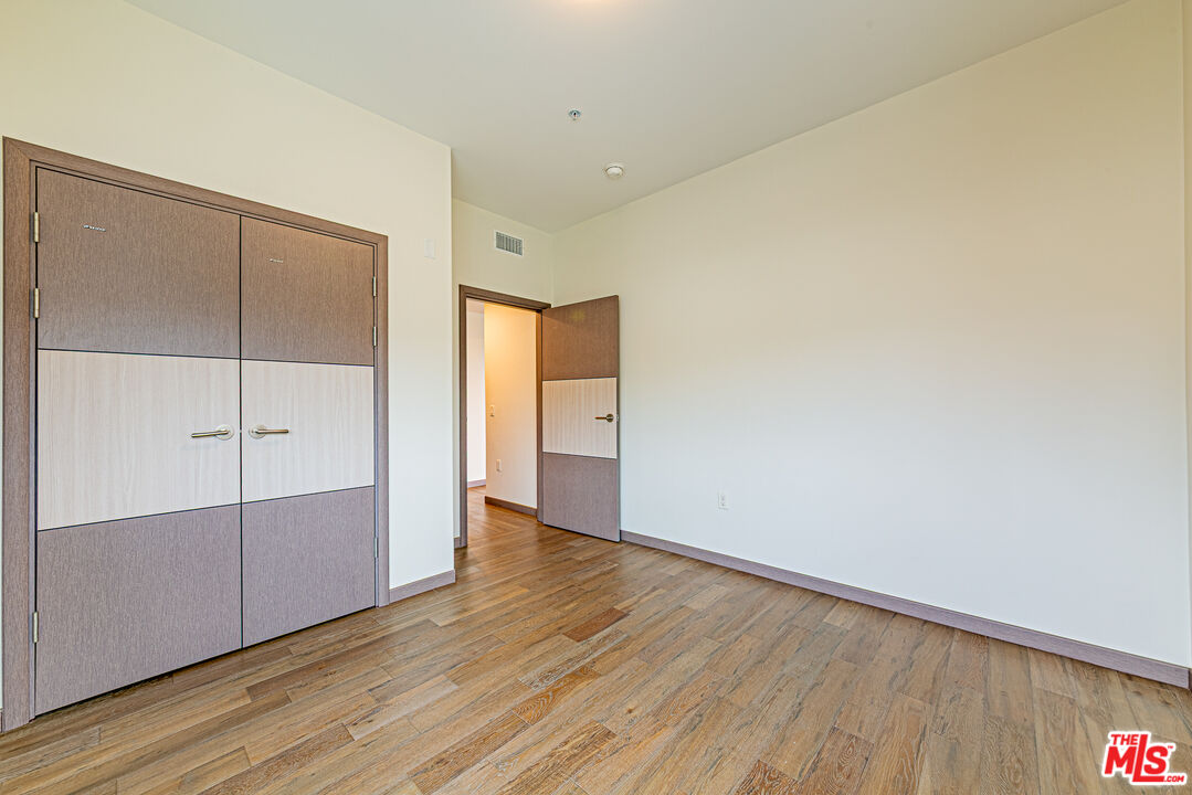 903 South New Hampshire Avenue, Unit 303 Los Angeles, CA 90006 - Photo 20 of 33 a view of an empty room with wooden floor
