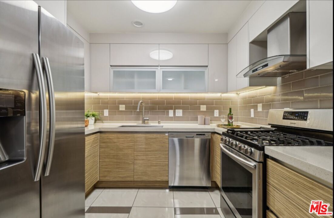 903 South New Hampshire Avenue, Unit 303 Los Angeles, CA 90006 - Photo 6 of 33 a kitchen with a stove a sink and a refrigerator