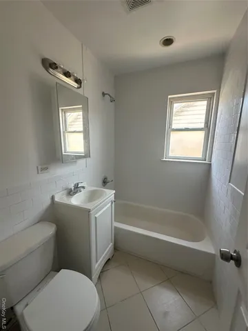 a bathroom with a sink toilet vanity and tub
