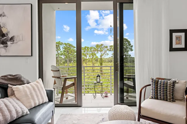 a living room with furniture and a floor to ceiling window