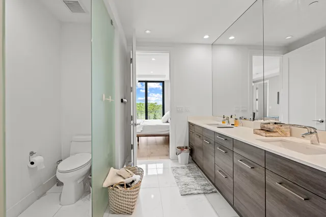 a bedroom with a bed and large windows