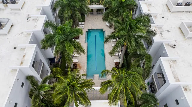 an aerial view of residential houses with outdoor space and trees