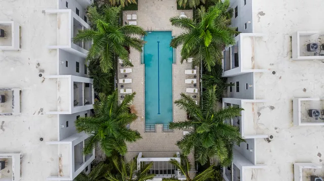 an aerial view of residential houses with outdoor space and trees