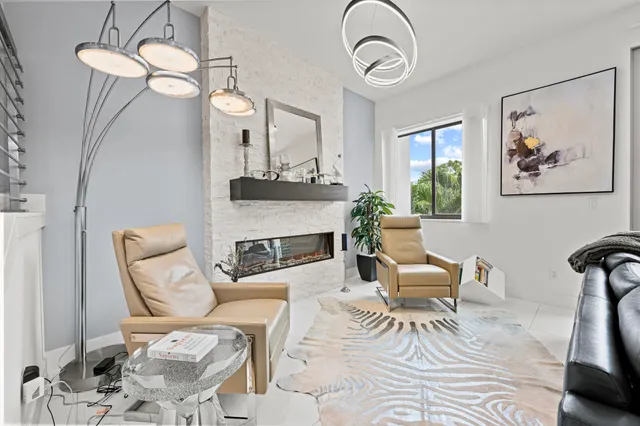 a living room with furniture a fireplace and a chandelier