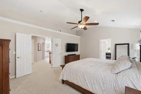 a bedroom with a large bed and a chandelier