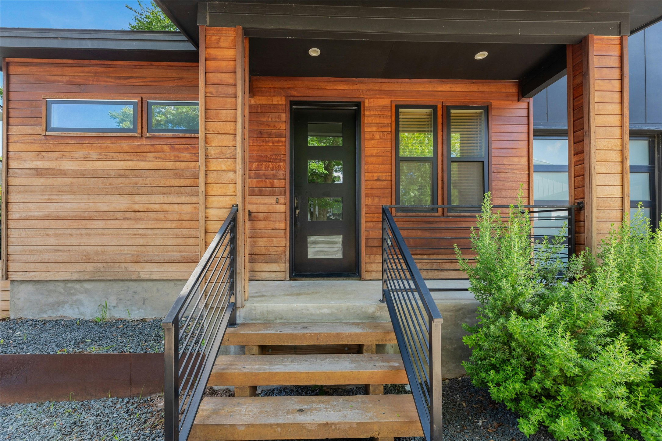 4606 Ledesma Road, Unit 2 Austin, TX 78721 - Photo 2 of 33 A striking contemporary entrance showcases rich wood siding and sleek metal railings.
