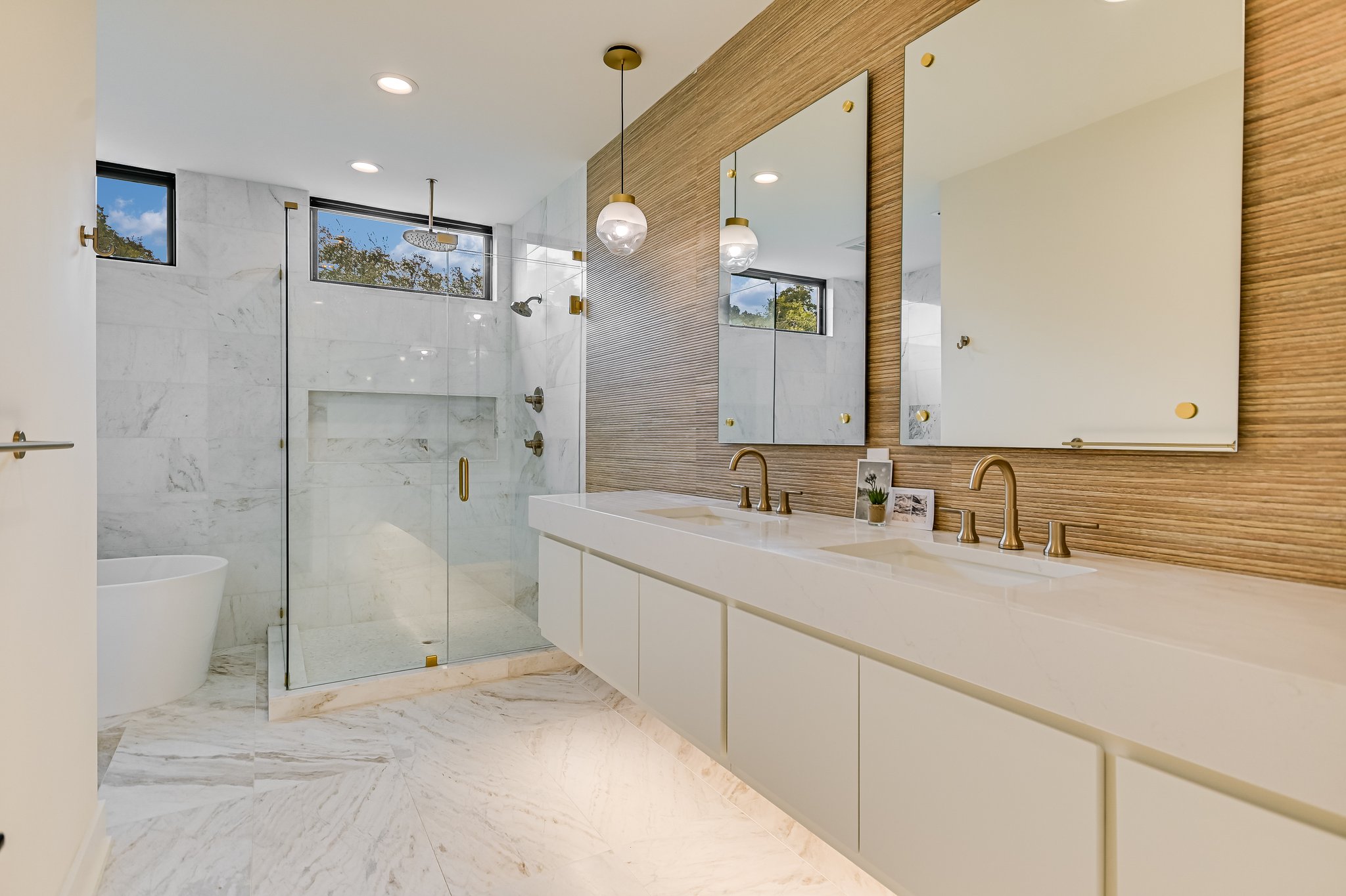 2015 De Verne Street Austin, TX 78704 - Photo 11 of 21 Bathroom with recessed lighting, double vanity, a marble finish shower, a freestanding bath, and light marble finish floors