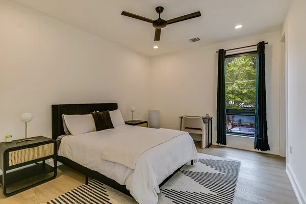 a bedroom with a large bed and a chandelier