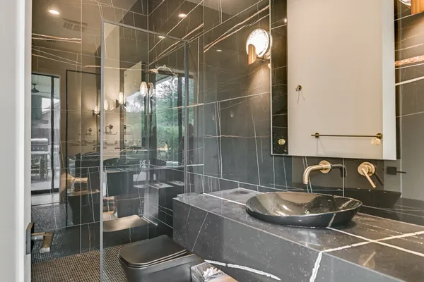 a bathroom with a granite countertop sink a toilet and shower