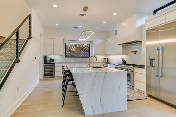 a large kitchen with stainless steel appliances a large counter top
