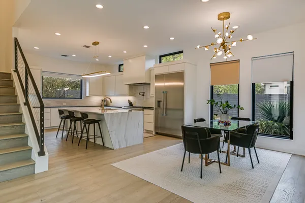 a dining room with furniture a chandelier and wooden floor