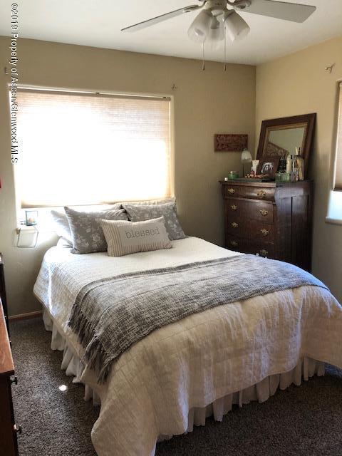 1424 Arabian Avenue Rifle, CO 81650 - Photo 6 of 14 a bedroom with a bed and a chandelier