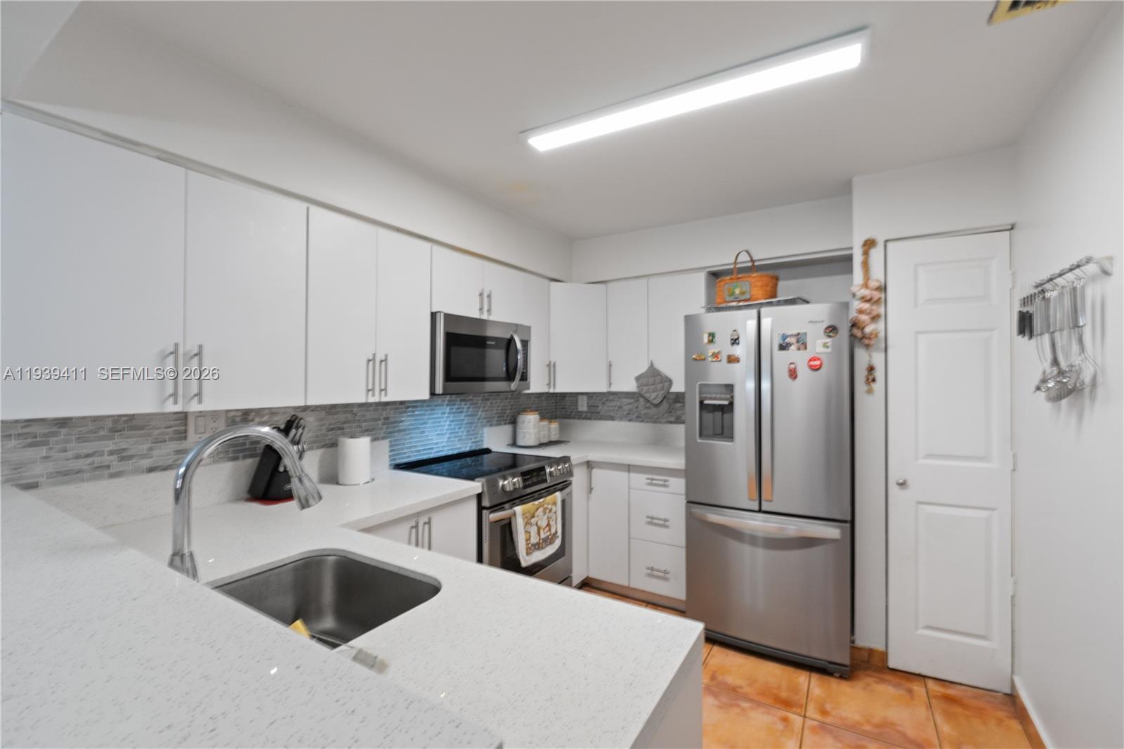 a kitchen with stainless steel appliances a refrigerator sink and microwave