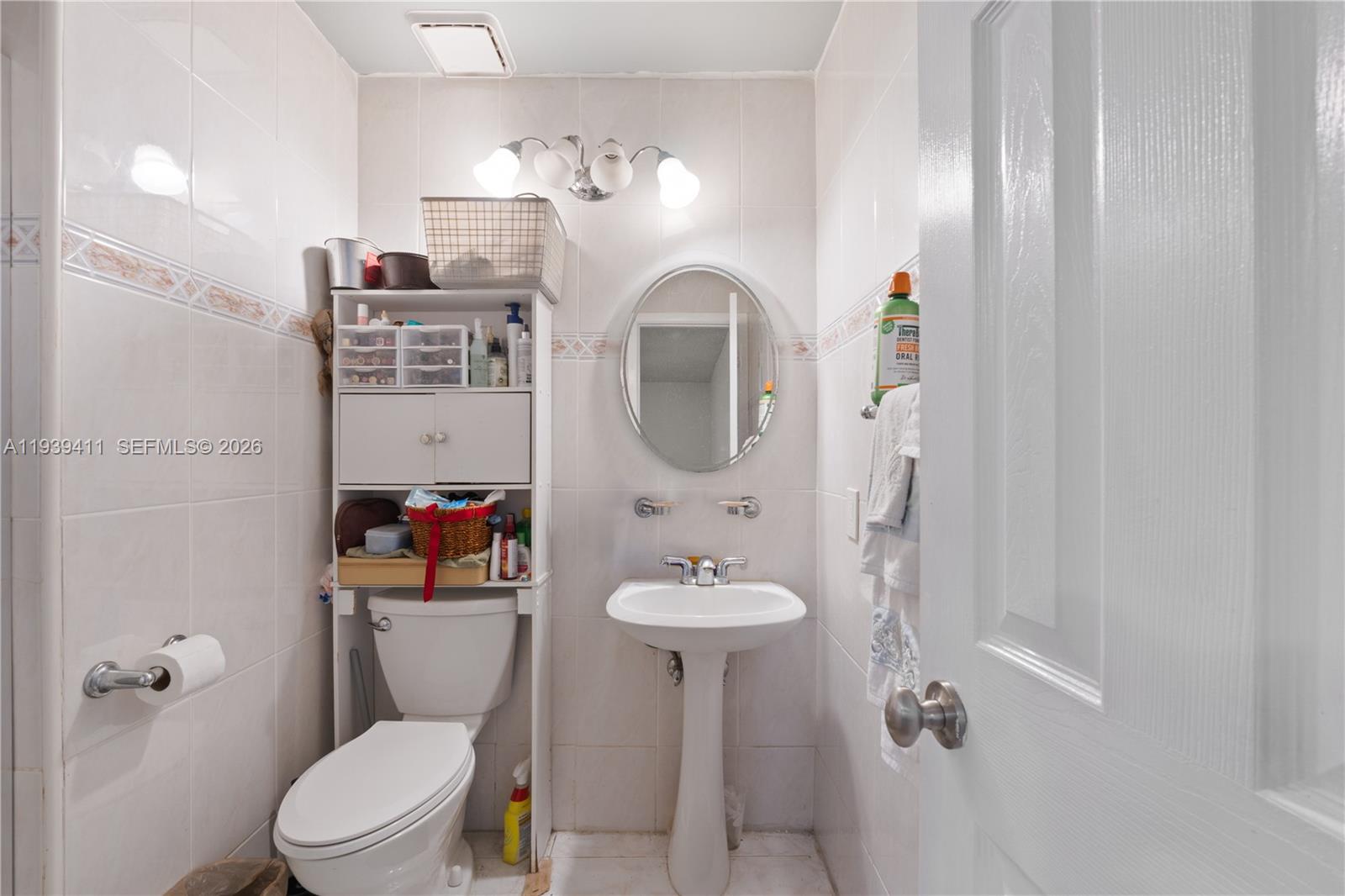 8480 Southwest 156th Place, Unit 620 Miami, FL 33193 - Photo 14 of 23 a bathroom with a sink a toilet and shower curtain