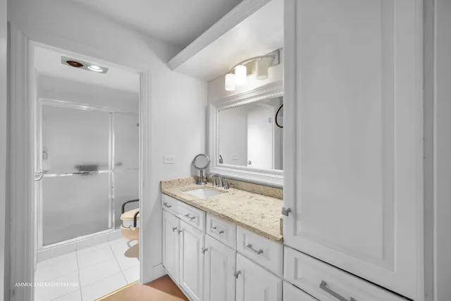 a bathroom with a granite countertop sink and a mirror